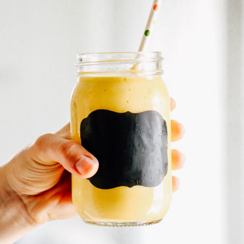 Mango pineapple smoothie in a glass mason jar.