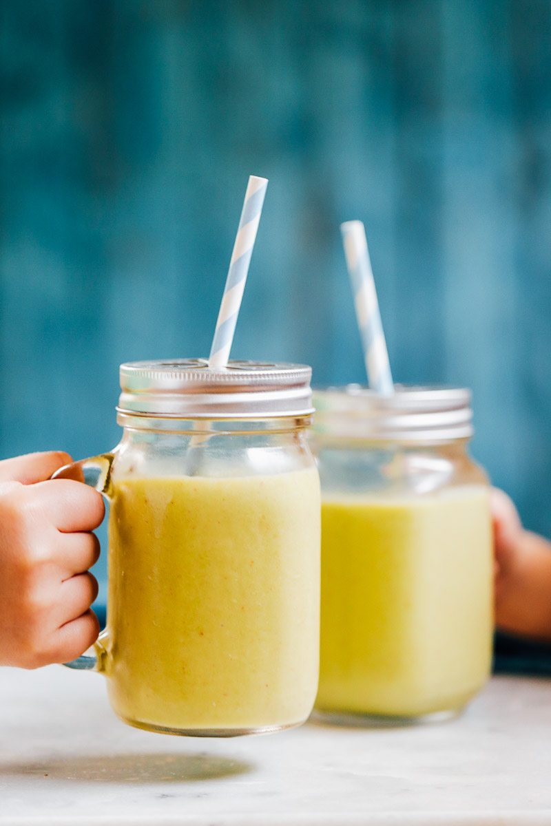 Tropical smoothies in glass mason jars with straws.