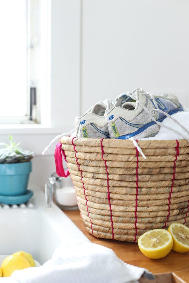 Laundry basket on the counter with shoes and towels inside.