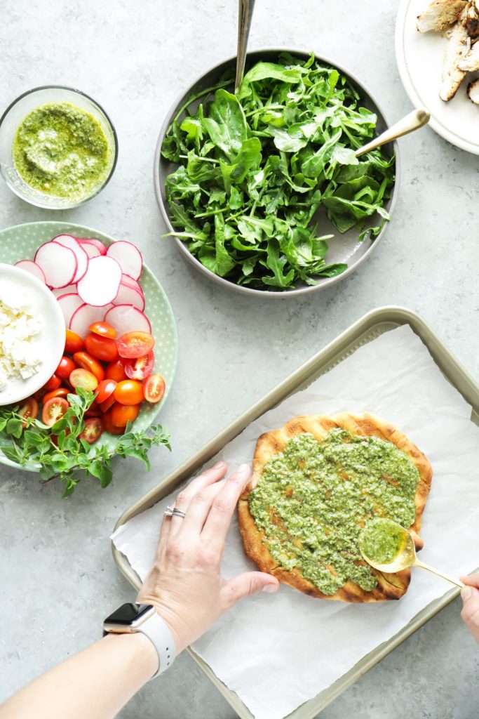 An easy and light summer meal featuring grilled pizza dough, homemade pesto, and fresh toppings.