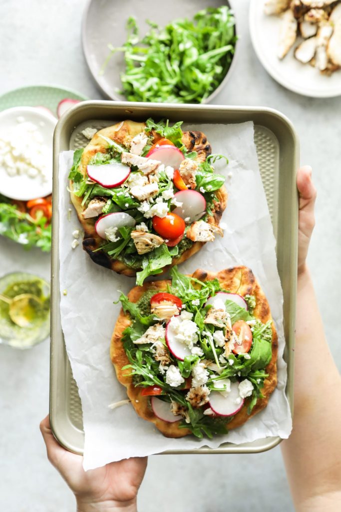 An easy and light summer meal featuring grilled pizza dough, homemade pesto, and fresh toppings.
