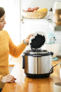 Pouring dried black beans from the colander into an Instant Pot.
