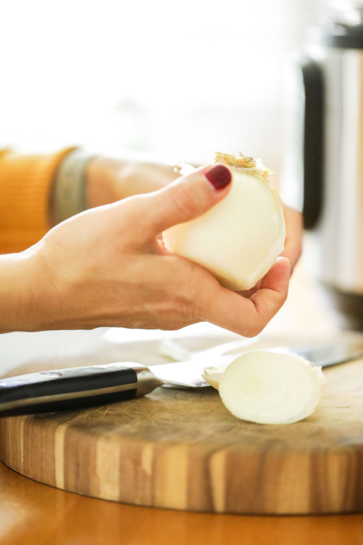 Peeling a white onion to add to the Instant Pot.