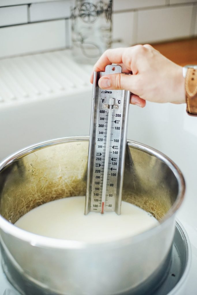 Placing a thermometer in the milk until it registers 110F