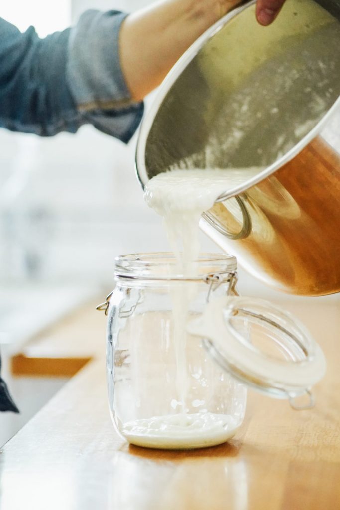 Pouring homemade yogurt from the Instant Pot into a storage jar