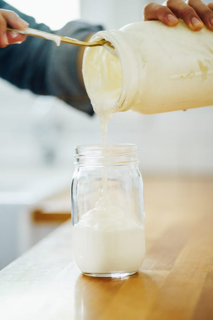 Pouring homemade yogurt into a jar