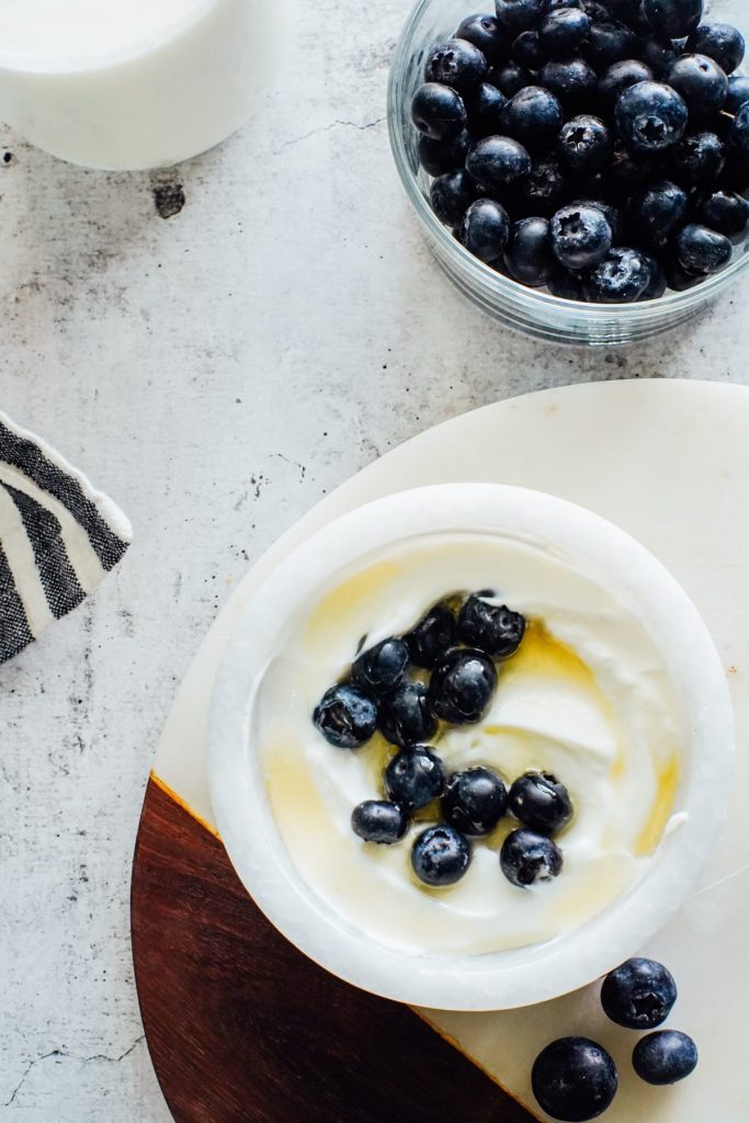 Homemade yogurt in a bowl with blueberries and honey