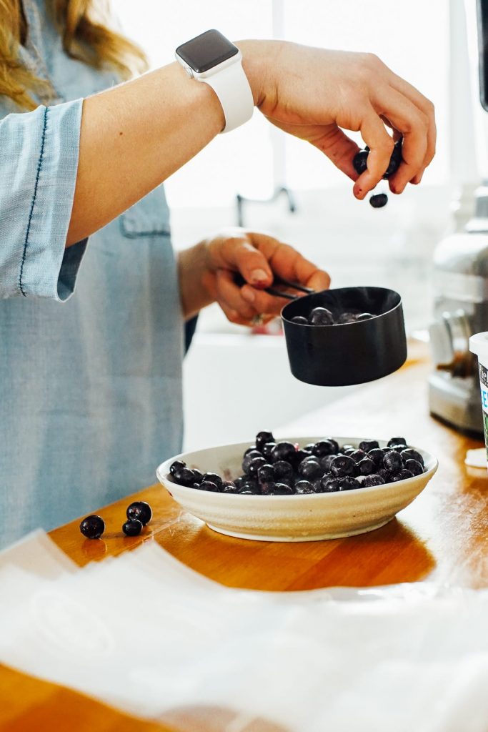 adding blueberries to the blender