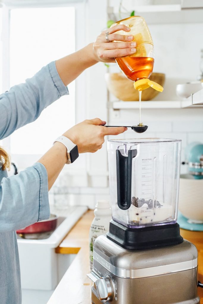 adding honey to the blender