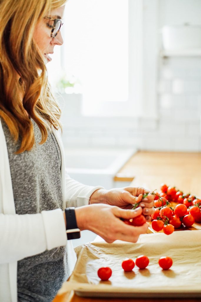 preparing tomatoes on a sheet pan to be roasted