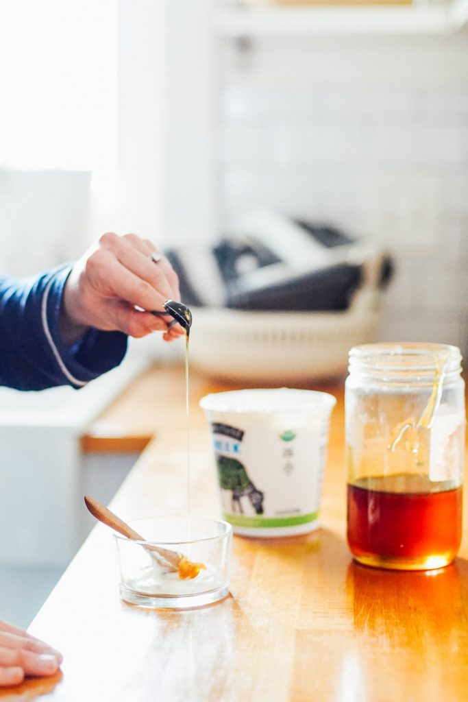 Adding honey to yogurt to make face mask