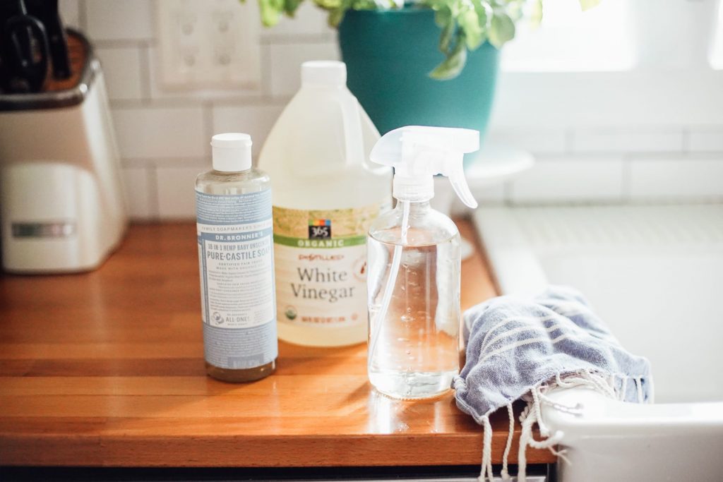 castile soap and vinegar next to a glass spray bottle