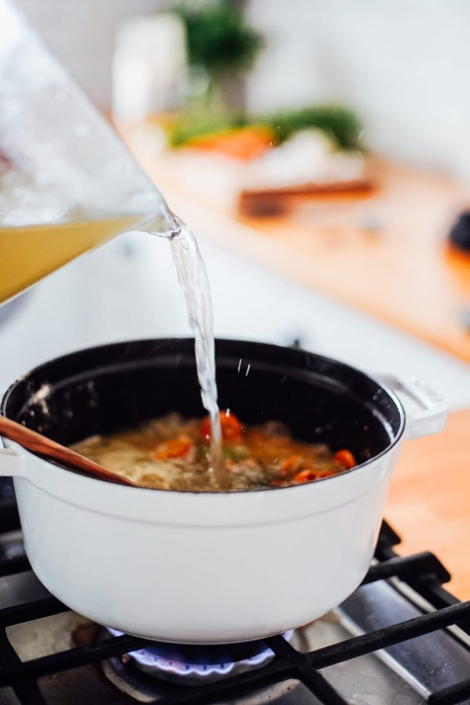 Adding broth to soup pot