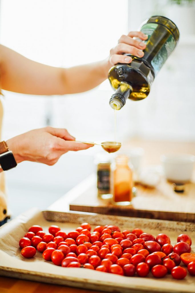 pouring olive oil over tomatoes