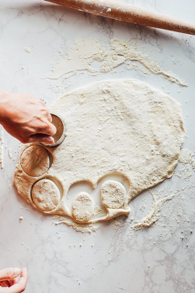 cutting pizza dough into rounds to make a homemade pizza lunchable