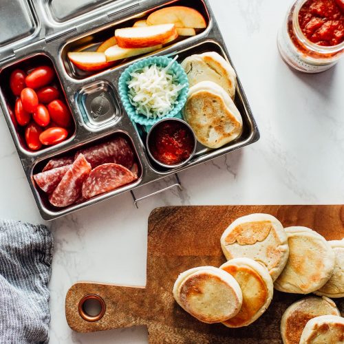 homemade pizza Lunchable packed in the lunchbox with salami, tomatoes, and apples