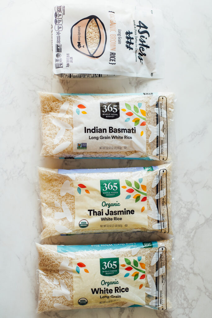 Brown rice, basmati rice, jasmine rice, and long grain white rice in bags waiting to be cooked.