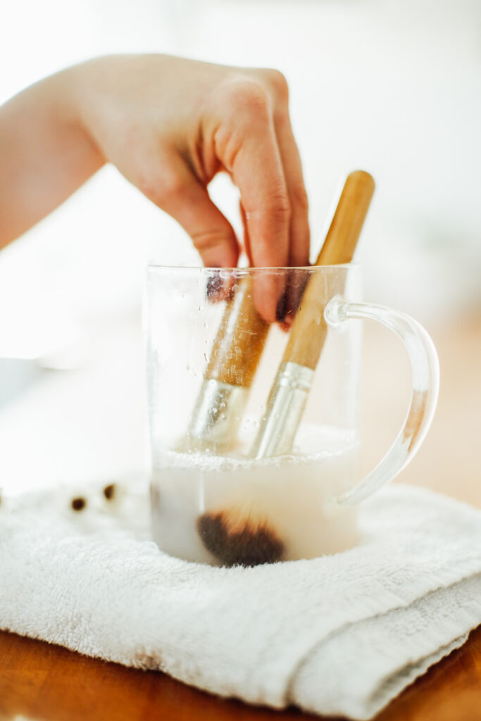 Makeup brush cleaner made with castile soap with makeup brushes soaking in the solution.