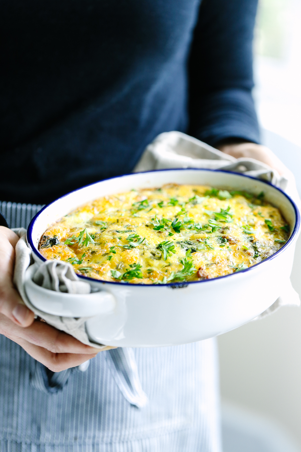 Egg casserole baked in a casserole dish with parsley sprinkled on top..