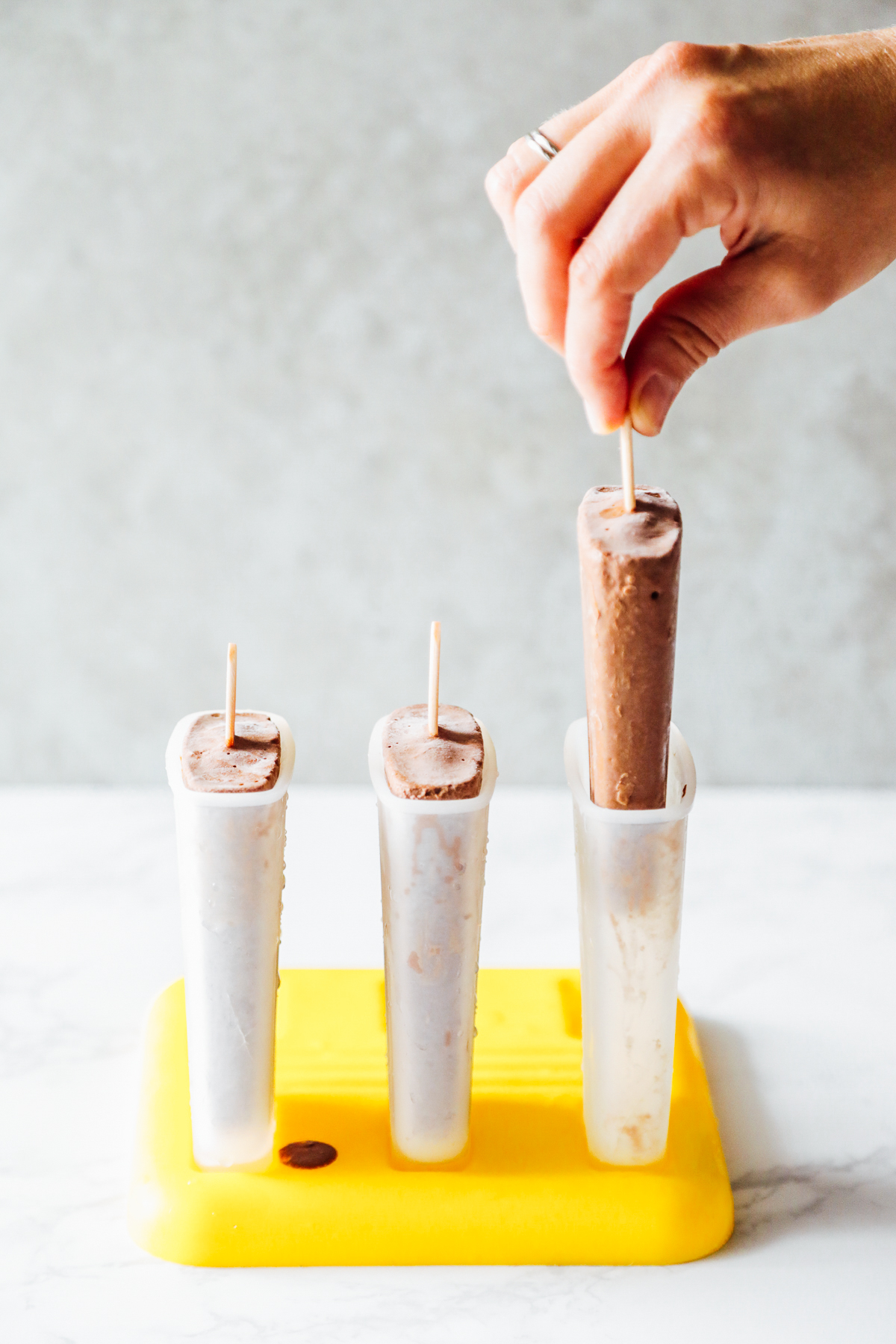 Pulling a homemade popsicle from a plastic mold.