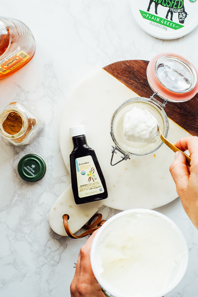 Adding Greek yogurt to a mixing bowl.