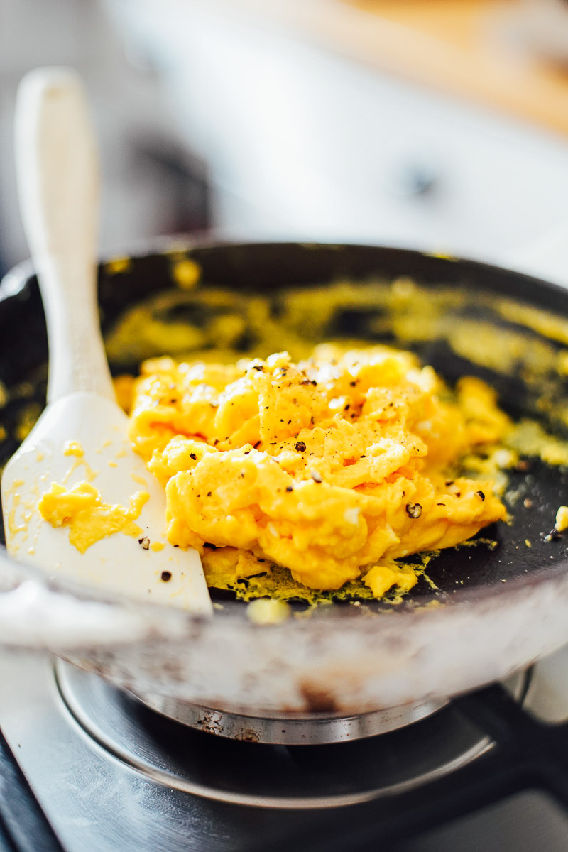 Cooked soft scrambled eggs in a cast iron skillet.
