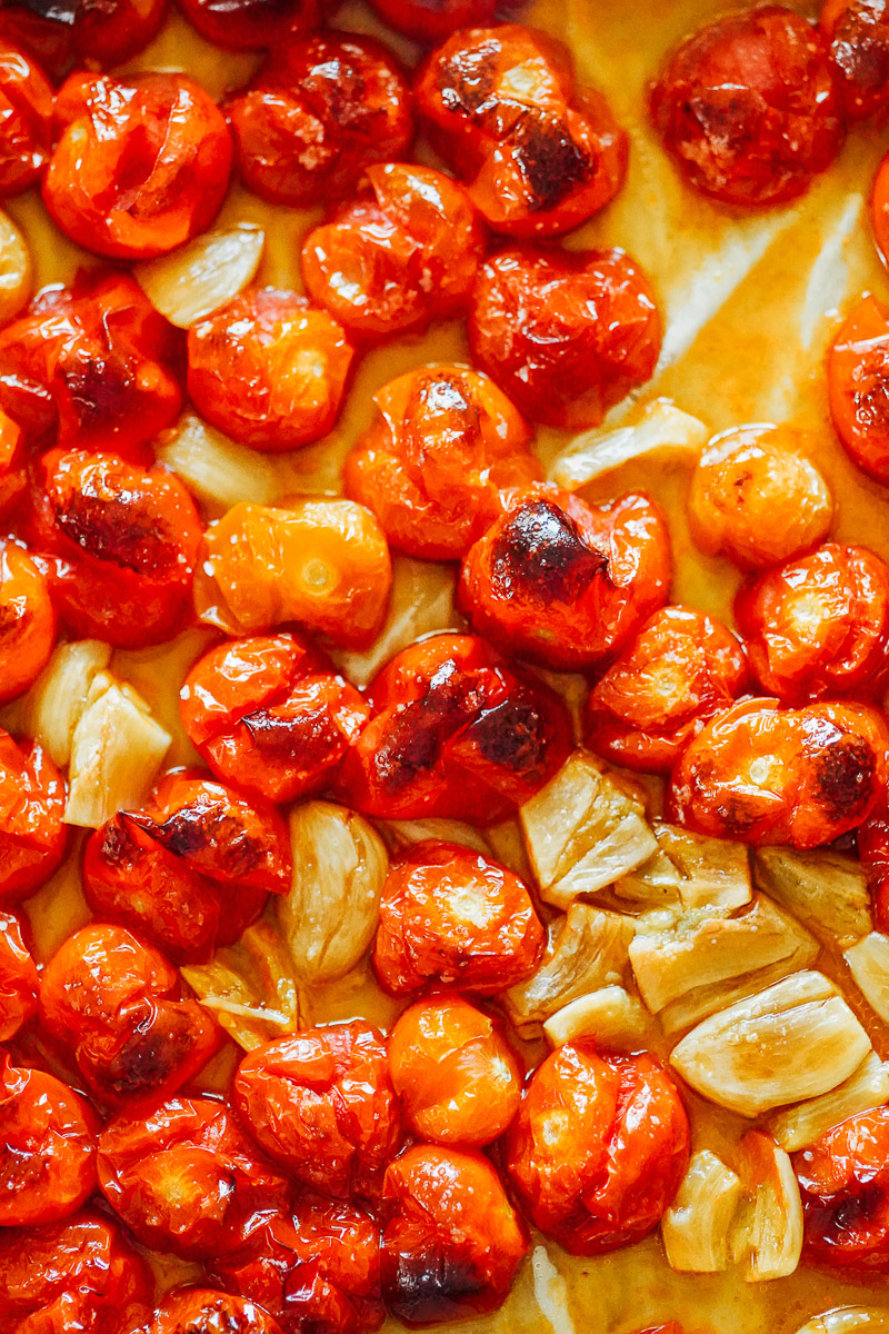 Roasted red cherry tomatoes on a sheet pan.