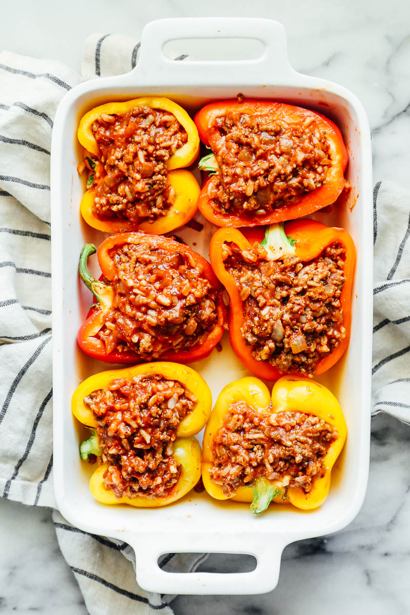 Ground beef and rice filling stuffed in bell peppers in a baking dish.