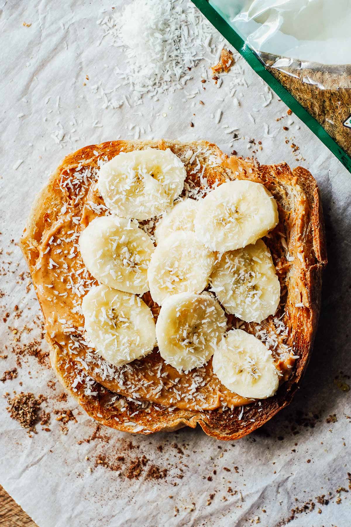 Banana slices on toast with peanut butter and coconut flakes over top.