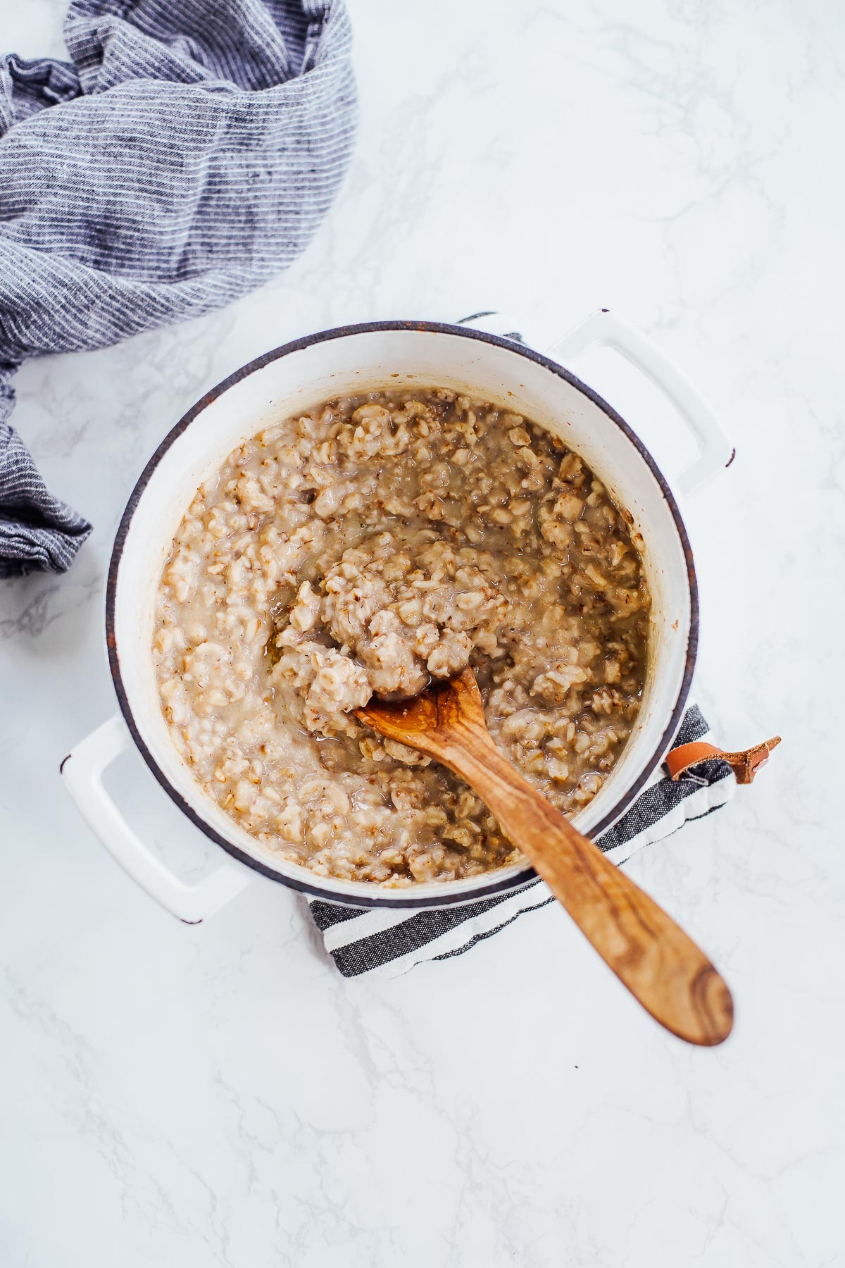 A pot of oats with a spoon dipping in.