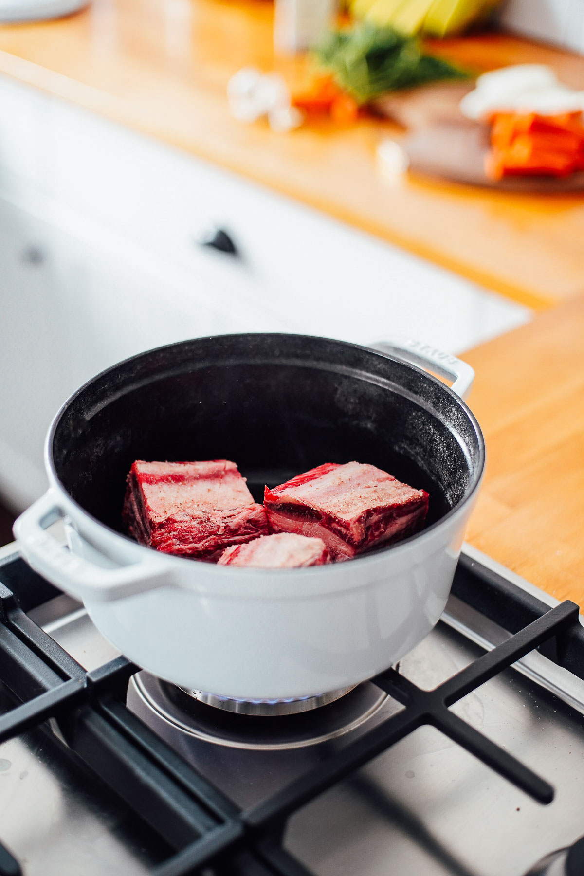 Short ribs in a dutch oven browning over the stove-top.