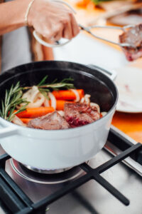Short ribs, carrots, and onion in a dutch oven over the stove-top.