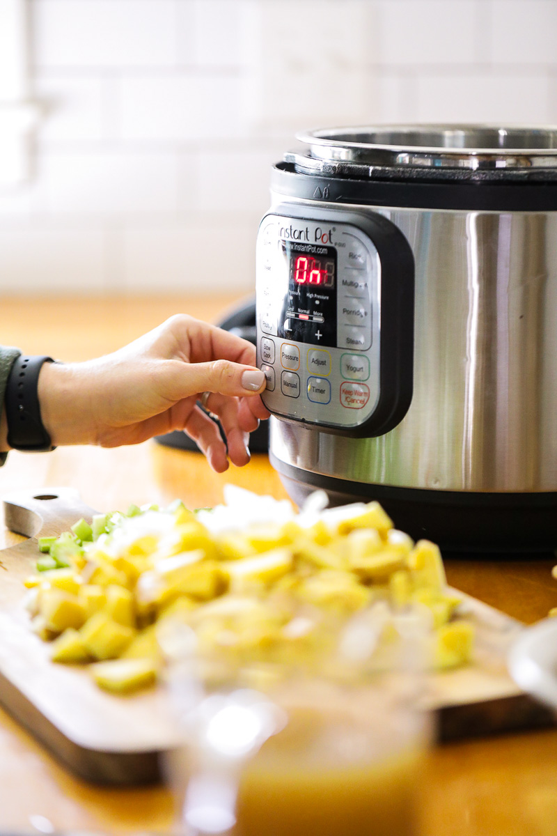 Pressing the saute button on the front of the Instant Pot.