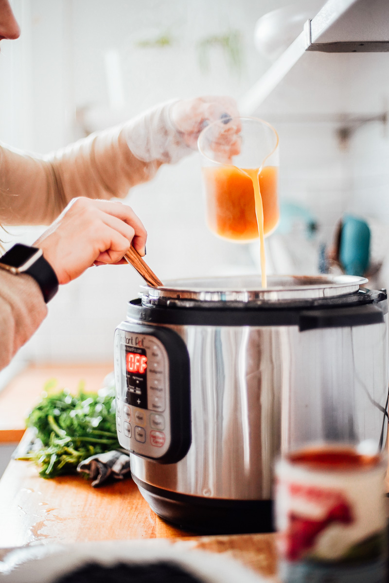 Pouring broth into the Instant Pot.