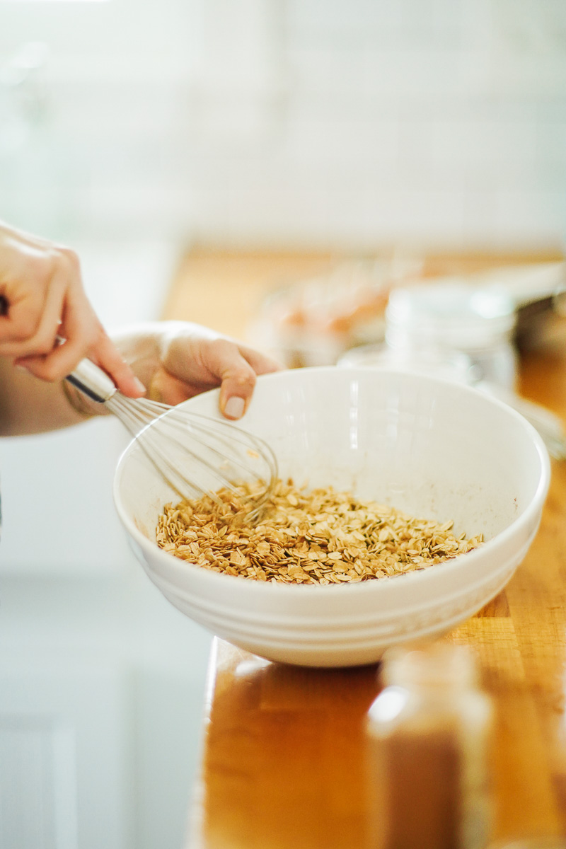 Whisking rolled oats in a large bowl with the other dry ingredients.