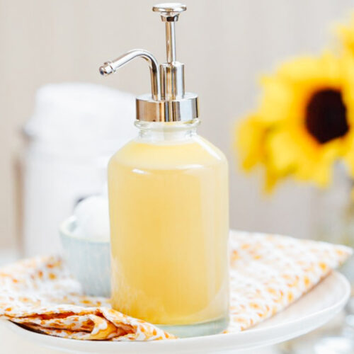 Honey face wash in a glass soap dispenser.