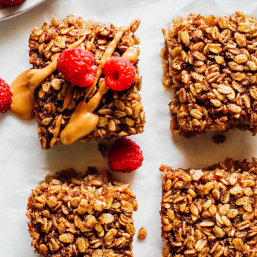 Baked oatmeal cut into bars with peanut butter and fruit.
