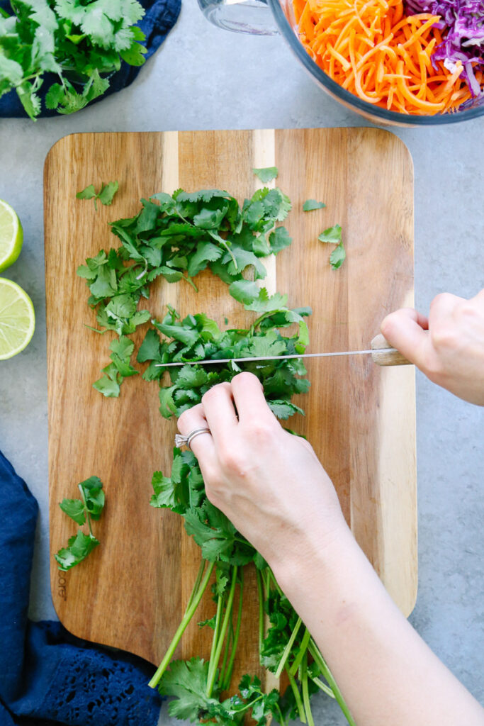 Chopping cilantro on a cutting board. 