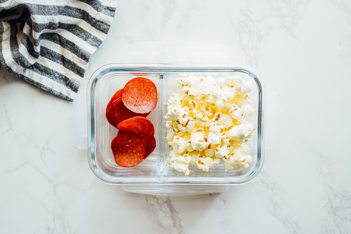 Popcorn and pepperoni in a snack container. 