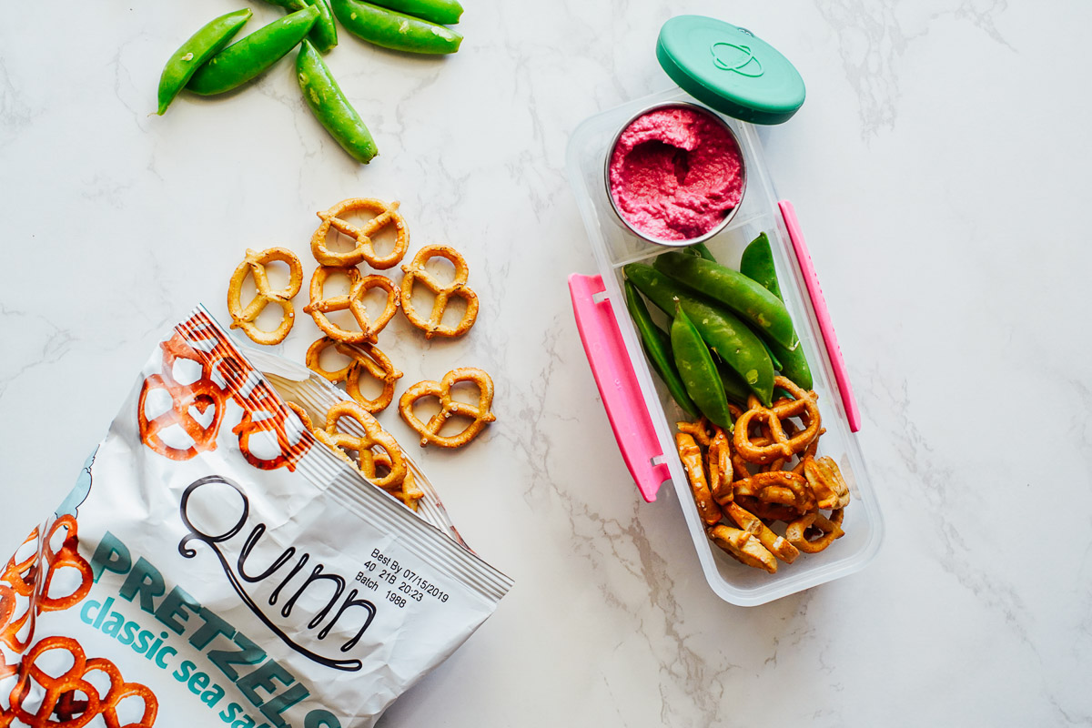 hummus, pretzels and snap peas in a snack container