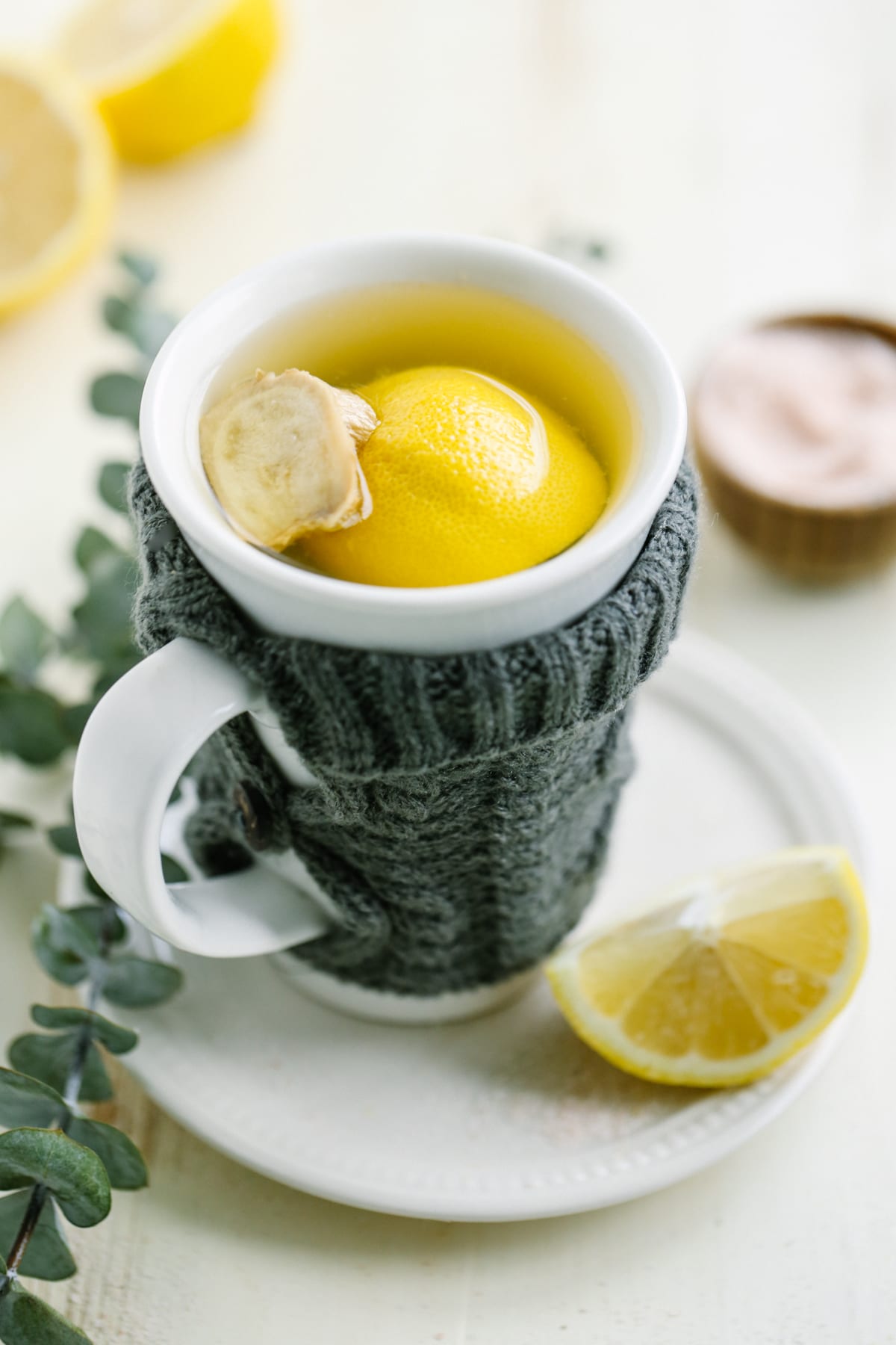Tea in a white mug with fresh lemon and ginger.