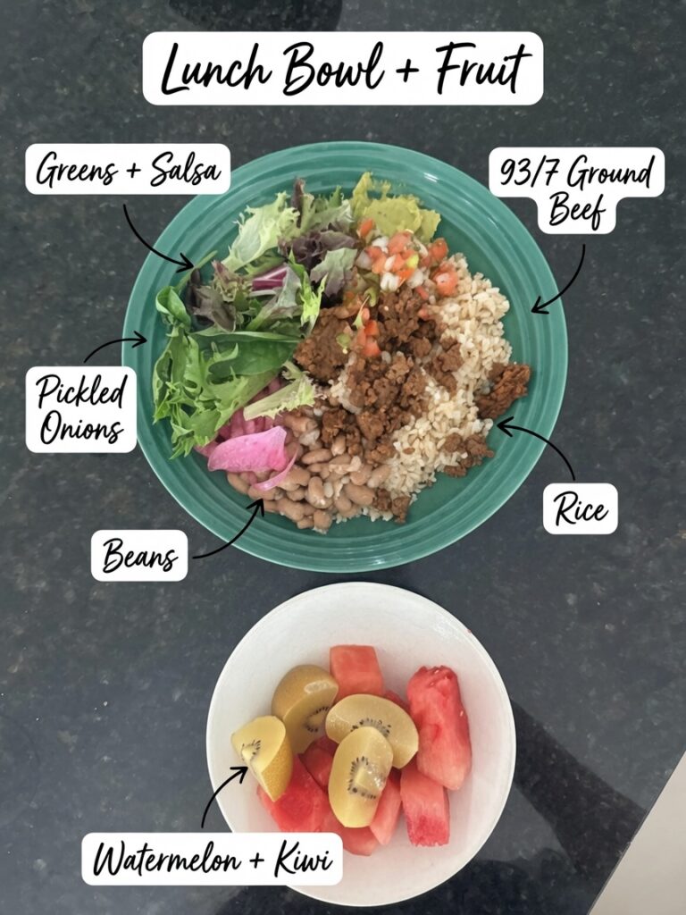 Lunch bowl with 93/7 ground beef, rice, beans, pickled onions, greens and salsa, served with a side of watermelon and kiwi