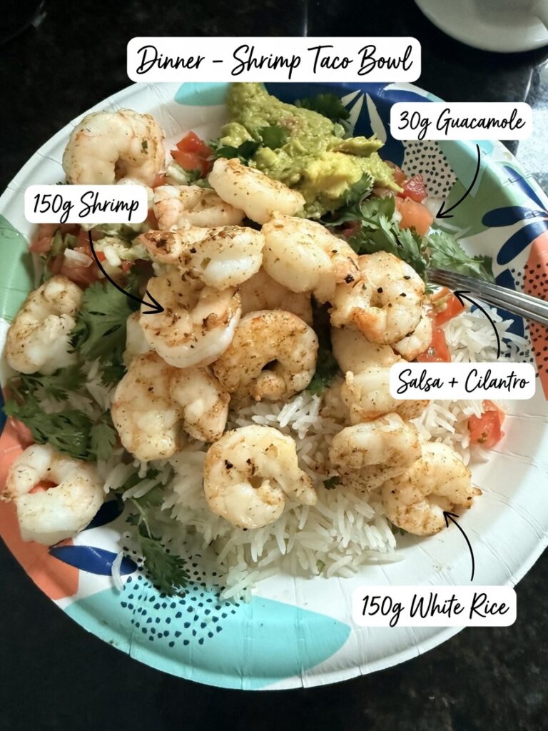 Shrimp taco bowl with seasoned shrimp, white rice, guacamole, salsa, and fresh cilantro